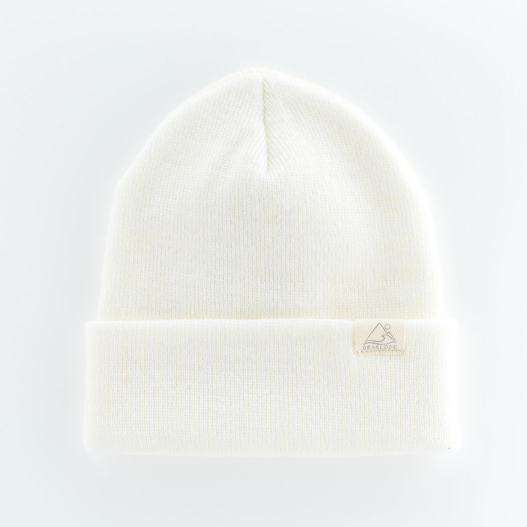 The DOVE YOUTH/ADULT BEANIE by seaslope1 is a simple yet stylish accessory crafted from white acrylic knit. Featuring a folded brim, this beanie offers a clean and minimalist look. Proudly made in the USA, it is presented on a light background that accentuates its understated design.