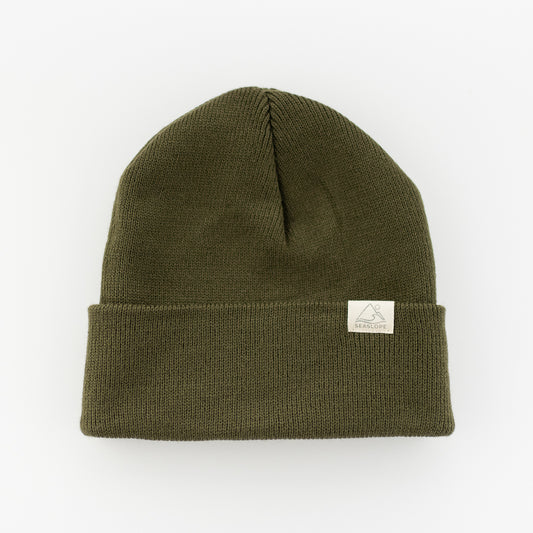 The EVERGREEN YOUTH/ADULT BEANIE by seaslope1 is crafted from 100% acrylic and features an olive green color with a folded brim. It provides a soft, stretch fit for comfort and sits perfectly flat against a plain white background.