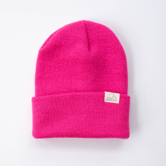 The Seaslope1 Fuchsia Infant/Toddler Beanie is a vibrant accessory crafted from 100% acrylic. It features a folded brim and has a small white label on the cuff, designed against a plain white backdrop. Made in the USA, this beanie combines style with quality.