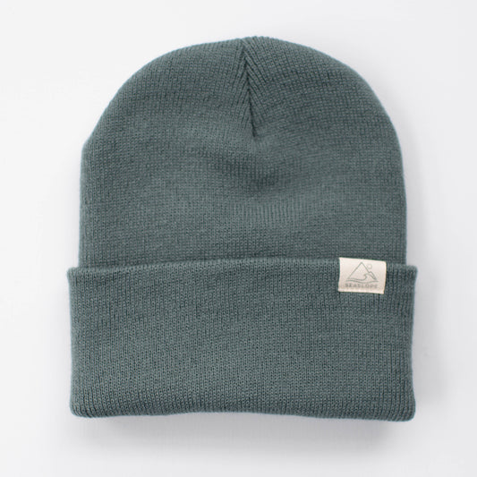 Introducing the SPRUCE YOUTH/ADULT BEANIE from seaslope1, a teal beauty featuring a folded brim and a small white label. Crafted in the USA from 100% acrylic, this beanie offers soft fabric and a minimalist design for stylish comfort.