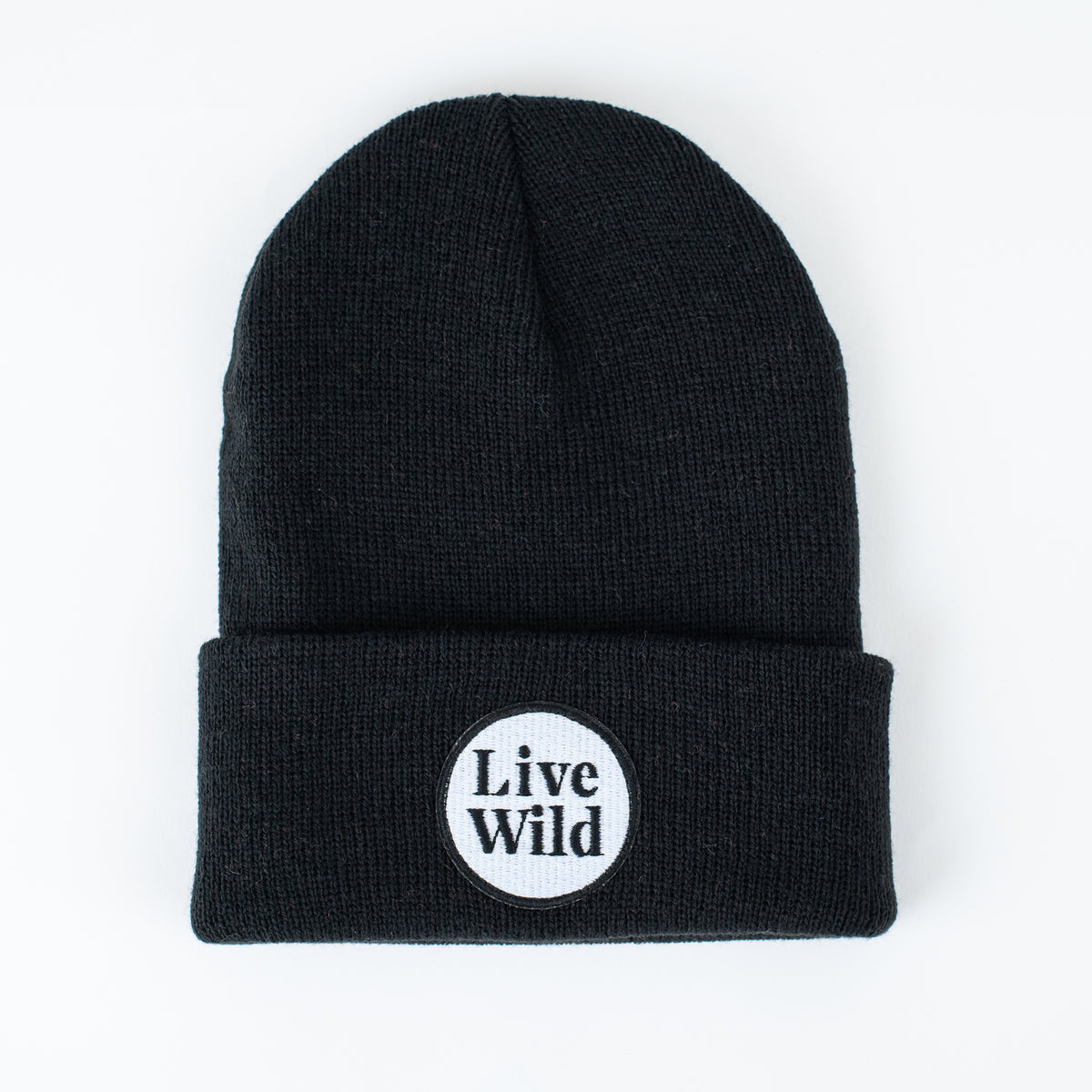 Product Description: Introducing the Live Wild - Jet Black Kids Beanie by seaslope1. This stylish beanie features a folded brim and a circular patch on the front with "Live Wild" text, set against a plain white background, making it an ideal accessory for kids.