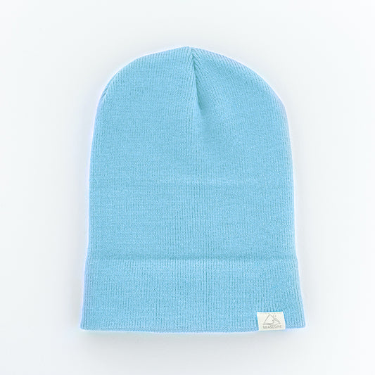 The seaslope1 SKY YOUTH/ADULT BEANIE is a light blue hat made from 100% Acrylic. It features a small white label on the cuff and displays a ribbed knit texture with a soft, stretchy fit.